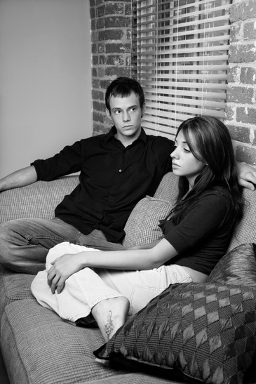 Young couple at home sitting on living room sofa